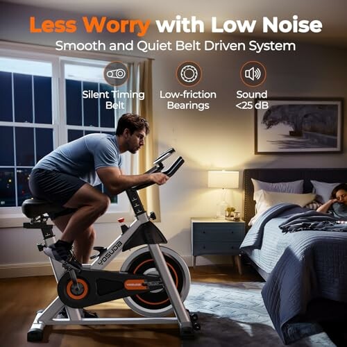 Man using a quiet exercise bike in a bedroom at night.