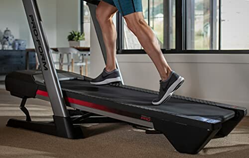 Person running on a treadmill indoors.